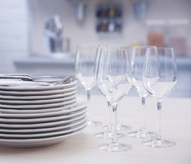 Prepared clean dishes for dinner party on a table in the kitchen