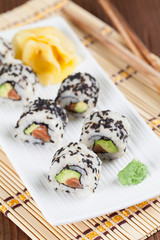 Uramaki sushi with avocado, raw salmon and black sesame