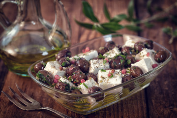 Greek Feta cheese with black olives decorated by olive leaves