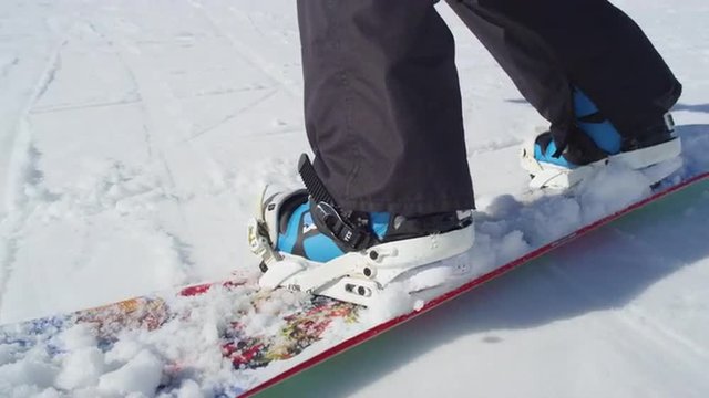 CLOSE UP: Snowboarder riding and jumping on ski slope