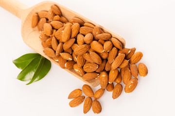 Heap of almonds in wooden spoon, healthy snack isolated over whi