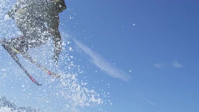 SLOW MOTION CLOSE UP: Freestyle skier  jumps over the kicker