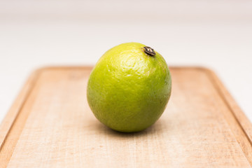 Ripe green lime with water drops on the cut-board