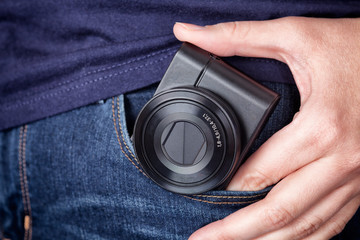 Person taking out a pocket camera out of pocket