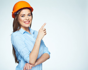 Smiling woman builder pointing finger on copy space.