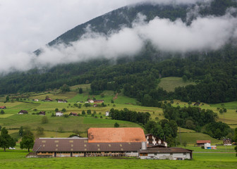 Farmland near Lucerne, Switzerland with clouds on the mountains