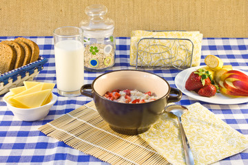 Still life breakfast of oat porridge with strawberries on a chec