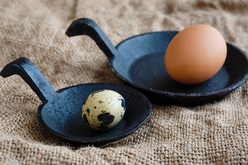 Quail and chicken eggs on a cast iron skillet