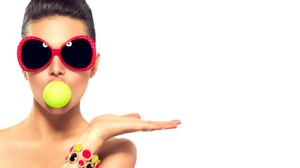 Fashion model girl wearing sunglasses with green bubble of chewing gum - obrazy, fototapety, plakaty