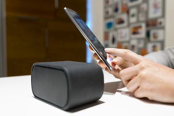 Woman connect their smart-phone to speakers. Nfc, bluetooth