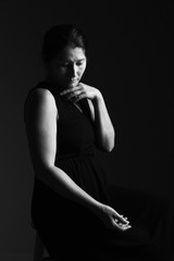 Woman prays on a black background