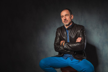 seated mature man in leather jacket