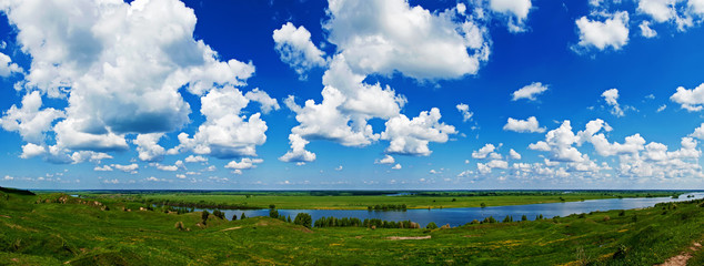 Obraz na płótnie Canvas cloudy blue sky over gently rolling patchwork farmland