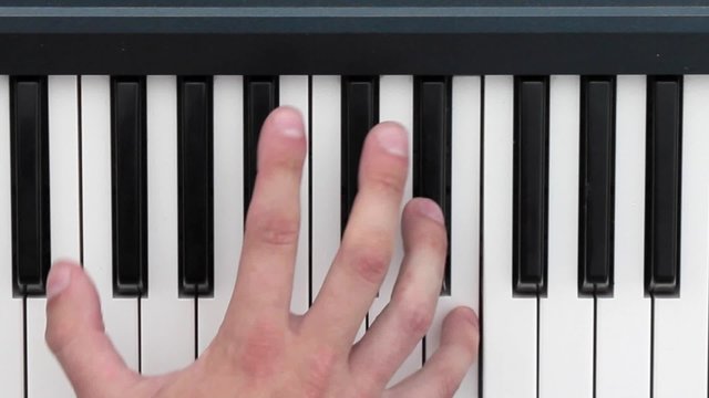 Hands playing music on the piano keyboard