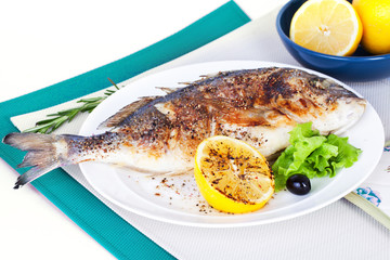 fish on a plate with lemon and olives in still life