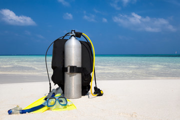 Taucherausrüstung mit Taucherbrille, Flossen und Atemregler am Strand
