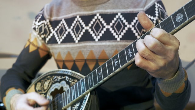 Young man playing on turkish saz guitar, 4k