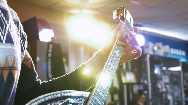 Young man playing on turkish saz guitar, 4k