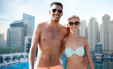 happy couple in swimwear over dubai city waterside