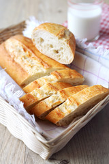 Baguette in wicker basket and milk