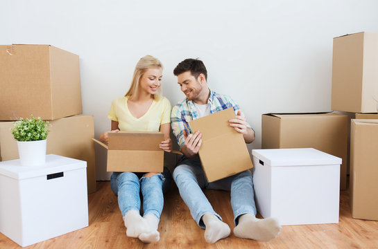 smiling couple with many boxes moving to new home