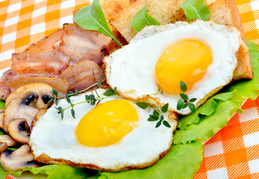 English breakfast - egg, toast,  bacon and salad.