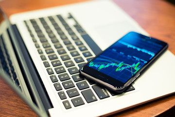 Laptop computer and Smartphone with stock market graph