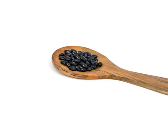close up black bean  on wooden spoon isolated white