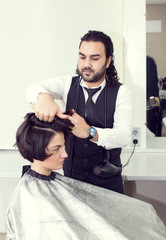 Hairdresser makes hair woman in a beauty salon