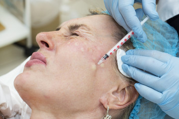 Naklejka premium Cosmetic treatment with injection in a clinic