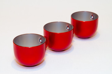 three red empty cups of tea (coffee) on white background