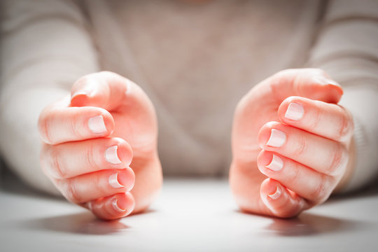 Woman's hands in gesture of protection, care. Concept insurance, security