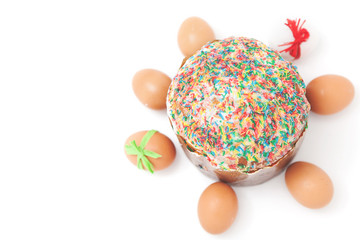 Easter eggs lie around cake on white background