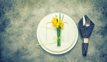 Table top with cutlery, napkin, spring flowers