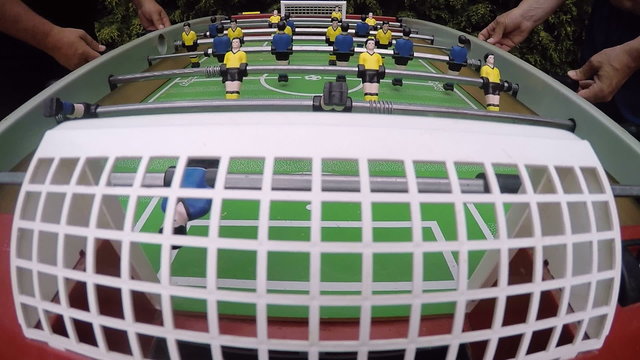 Foosball players having fun playing table soccer outdoors