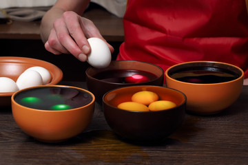 Preparing for the holiday Easter. The process of painting eggs with food coloring 