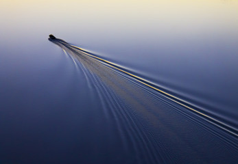 fisherman floats on a motor boat, river, lake, sea, sunset, sunrise