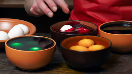 Preparing for the holiday Easter. The process of painting eggs with food coloring 