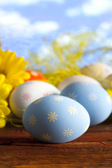 Easter eggs and flowers on blue sky background
