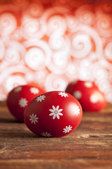 Red Easter eggs on wooden table and patterned background