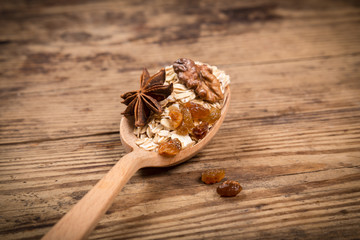 wood spoon with raw oatmeal grains and spices