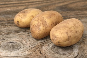 Fresh potatoes on wooden background
