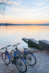 Fototapeta na wymiar A pair of bicycles in the lake at sunset