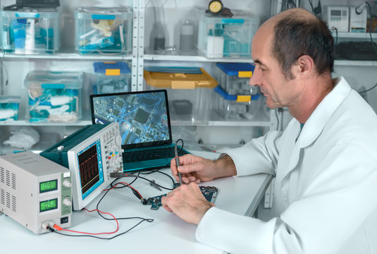 Senior male tech works in hardware repair facility