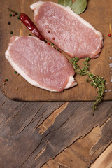 Fresh meat steaks on old wooden cutting board