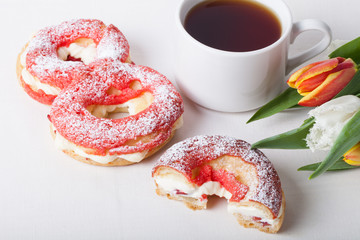Homemade custard cakes with cream and bunch of spring tulips on