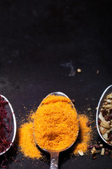 Ancient melchior spoons with spices on metal surface for backgro