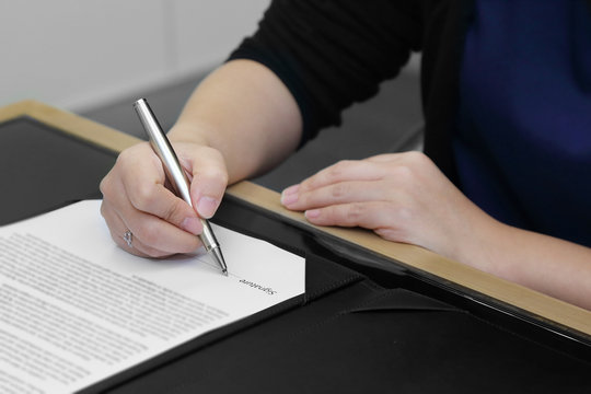 businesswoman's hand signing the contract with pen