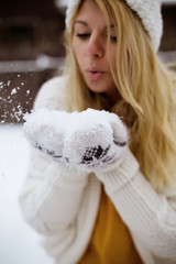 woman throwing snow in the air on winter holidays