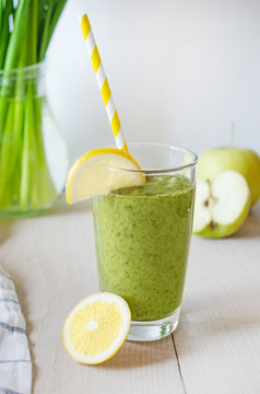 Healthy green smoothie with spinach and apple in a glass on wood